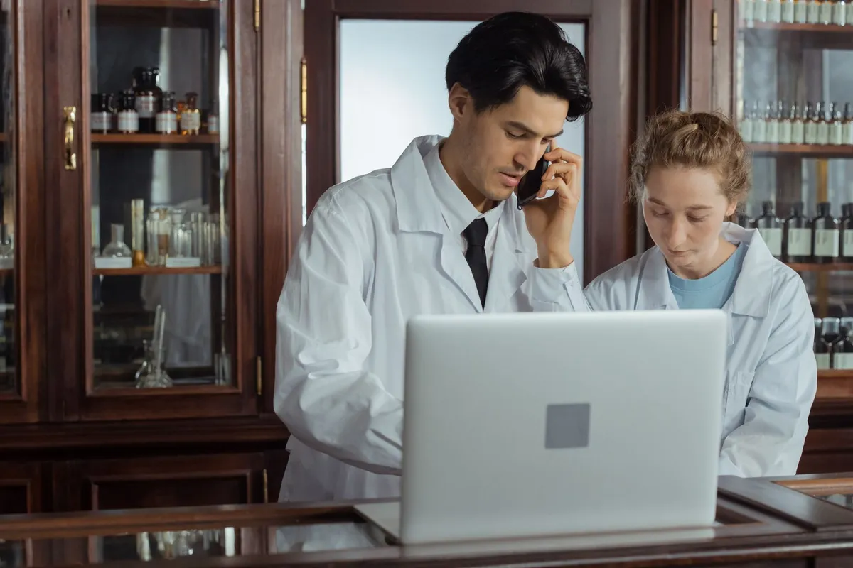 Two pharmacists working together behind a pharmacy counter